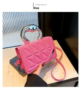 Detailed close-up of pink quilted crossbody bag with stylish silver metal ring handles
