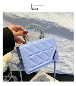 Detail of light blue quilted crossbody bag with unique silver liquid metal handle