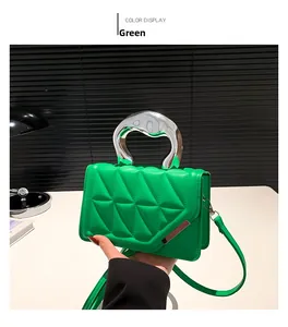 Detail view of green quilted PU leather bag with elegant curved silver metal handle