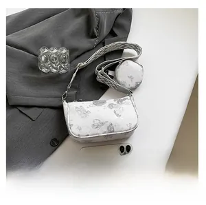 Détail du sac blanc à motif papillon, bandoulière tissée large et petit porte-monnaie rond