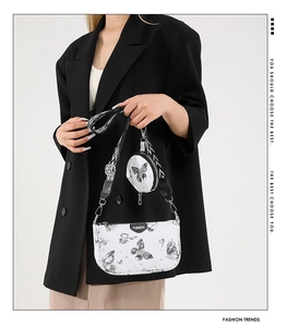 Détail du sac bandoulière blanc imprimé papillon avec sangle à motifs et bourse