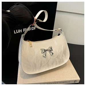 Close-up of white marble pattern crescent bag with silver metal bow and gold zipper