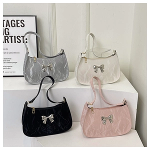 Detailed display of four bow-decorated crescent bags in silver, white, black, and pink