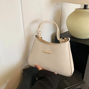Detailed close-up of cream shoulder bag with textured woven faux leather and rope handle