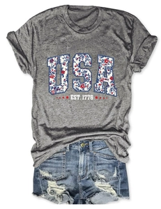 Detailed flat lay of USA EST 1776 grey cotton t-shirt with floral print lettering