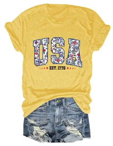 Detail of USA floral lettering on mustard yellow T-shirt and distressed denim shorts set