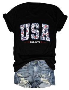 Close-up of USA EST. 1776 floral print on black T-shirt and distressed denim shorts