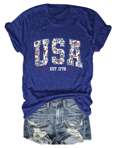 Detailed view of USA EST. 1776 floral print on royal blue t-shirt and ripped denim shorts