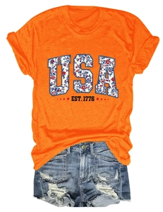 Detailed close-up of orange USA EST. 1776 floral print t-shirt and ripped denim shorts