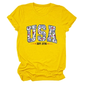 Close-up of bright yellow T-shirt featuring floral USA letters and EST. 1776 print