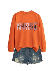 Dettaglio della felpa arancione con stampa Nurse Med Surg e pantaloncini denim