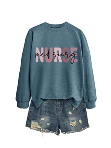 Dettaglio della stampa rosa 'NURSE' sulla felpa blu grigio con pantaloncini in denim strappati