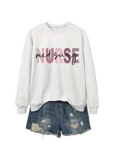 Dettaglio flat lay di una felpa grigia con stampa NURSE med surg e pantaloncini denim