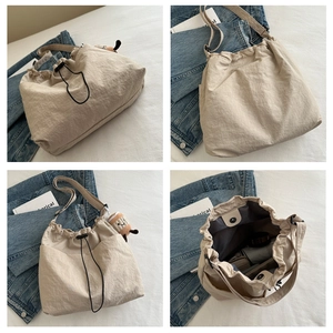 Detalles macro del bolso cubo de nailon plisado beige con cierre de cordón y compartimento