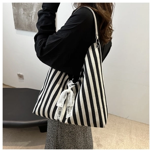 Detail of canvas tote bag with black and white zebra stripes and white lace bow accessory