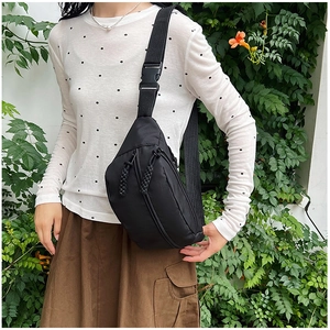 Détail du sac bandoulière en toile noire imperméable avec sangle réglable et boucle