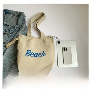 Capacity detail of beige tote bag showing size comparison with a tablet and phone