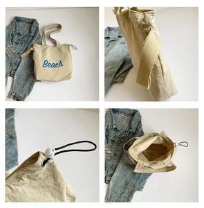 Detail view of cream canvas tote bag with blue Beach print and drawstring adjustment