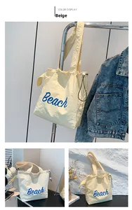 Detail of yellow tote bag featuring blue Beach print and adjustable drawstring closure