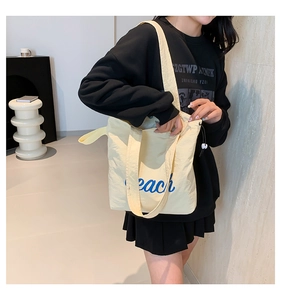Close-up of cream canvas tote bag with blue peach print and adjustable drawstring detail