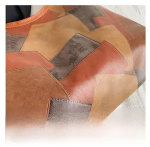 Macro detail of patchwork leather tote showing geometric panels and visible stitching