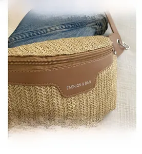 Close-up of woven straw chest bag with brown leather flap and fashion logo