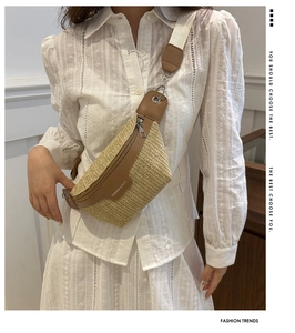 Straw woven crossbody bag with leather trim and wide strap shown on a female model