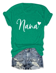Flat lay of a green crew neck Nana heart t-shirt paired with distressed blue denim shorts