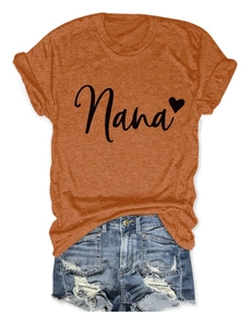 Close-up of caramel t-shirt Nana heart print and distressed denim shorts detail