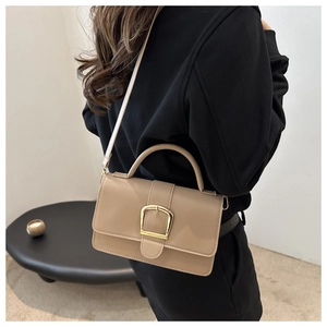 Sac à main carré beige minimaliste avec boucle dorée présenté sur un mannequin de dos