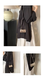 Detail der silbernen Metallic-Tasche mit Wellenstruktur und feiner Gliederkette