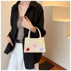 Minimalist beige canvas handbag with colorful leather heart patches and dual handles