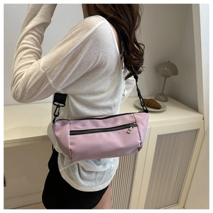 Detailed side view of a light purple nylon crossbody bag with black adjustable strap