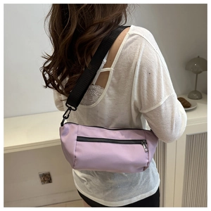 Model wearing a light purple nylon crossbody bag with black shoulder strap and zipper pocket