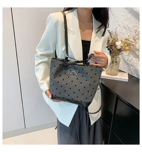 Detailed view of gray fabric tote bag featuring black polka dots and silver bow buckle