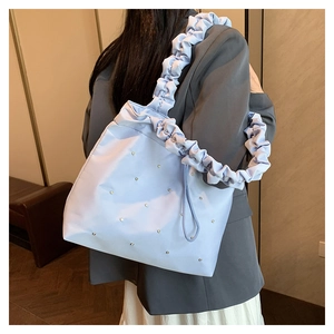 Detail of light blue tote bag with ruched shoulder strap and sparkling crystal rhinestones