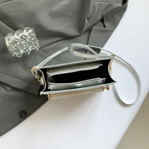 Silver mini crossbody bag with faux pearl handle and stone pattern in a top-down view