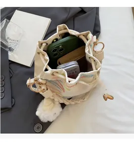 Spacious interior of off-white drawstring bucket bag with chic embroidery detail