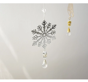 Detail of silver snowflake metal ornament with transparent crystal beads and water drop pendant