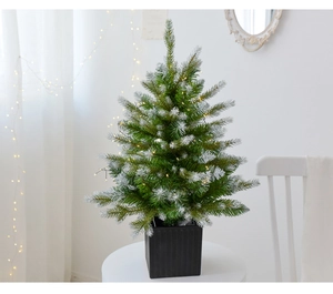 Detailed view of a 60cm tabletop PE Christmas tree with white snow and LED lights