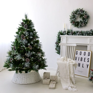 Frosted artificial Christmas tree with pine cones and LED lights on a white base