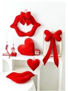 Detailed view of red velvet heart and lip-shaped holiday ornaments on white stairs