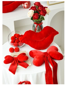 Detail of red velvet lip pillow and bow cushion set on festive table arrangement