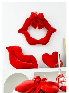 Detailed view of red velvet lip wreath with bow and matching heart shaped pillows