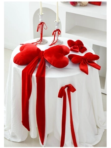 Close-up of red velvet heart bow pillow and matching ribbons for romantic decor