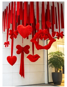 Detail view of hanging red velvet bow heart and lip decorations for festive party scenes