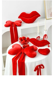 Close-up of red velvet heart and lip-shaped decorative pillows for romantic scene setups