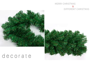 Detail of dense green PVC Christmas garland with realistic pine needle texture