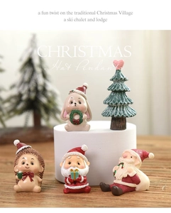Detailed view of five Christmas figurines including Santa and reindeer on a wooden table
