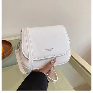 Detail of white PU leather crossbody bag featuring Fashion Trend EST 1995 text and strap